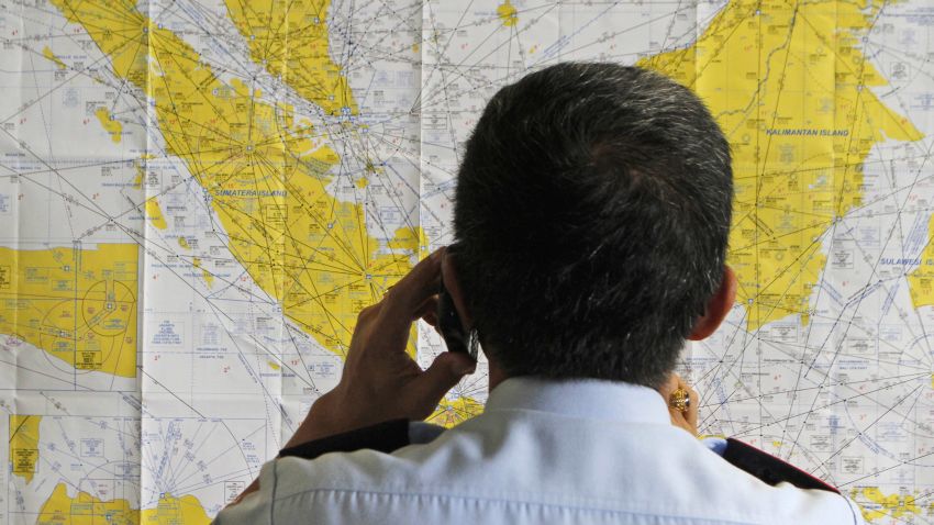 An airport official checks a map of Indonesia at the crisis center set up by local authority for the missing AirAsia flight QZ8501, at Juanda International Airport in Surabaya, East Java, Indonesia, Sunday, Dec. 28, 2014. The AirAsia plane with over 160 people on board lost contact with ground control on Sunday while flying over the Java Sea after taking off from the provincial city in Indonesia for Singapore. (AP Photo/Trisnadi/AP)