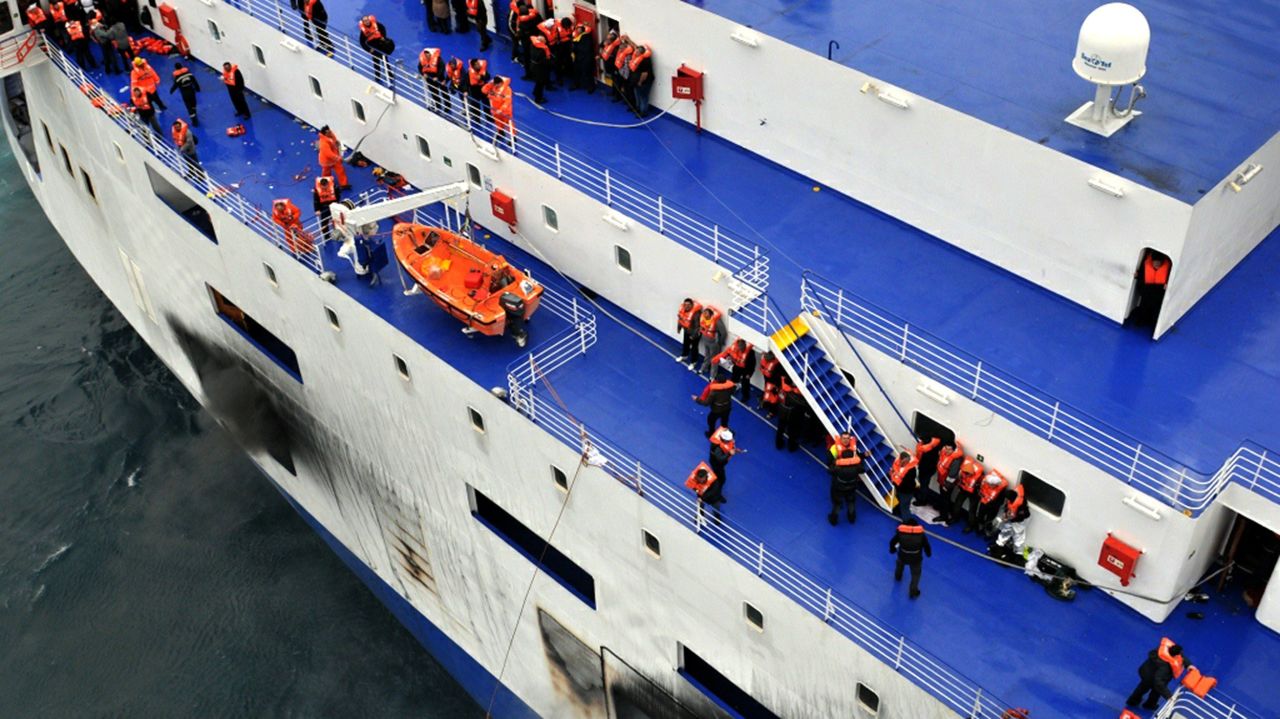 Passengers wait to be rescued from the burning ferry.