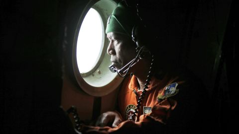 An Indonesian military airman looks out the window of an airplane during a search over the waters of Karimata Strait on Monday, December 29.