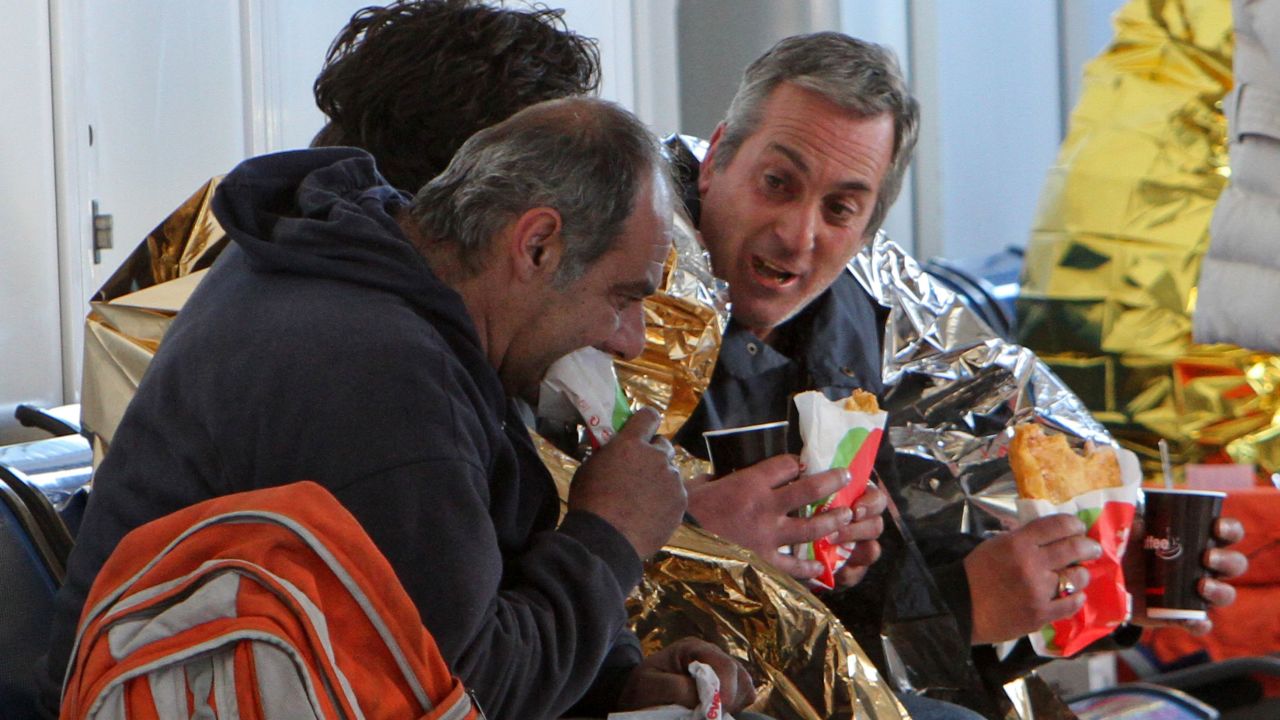 Passengers eat after their arrival at the airport of Corfu island in Greece on December 29.