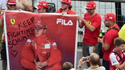 A man takes a photograph of Scuderia Ferrari's supporters as they hold a banner that reads, 'Keep fighting Schumi ' referring to former F1 legend Michael Schumacher, severely injured in December 2013 in a skiing accident in France, at the Autodromo Nazionale circuit in Monza on September 4, 2014 ahead of the Italian Formula One Grand Prix on September 7. AFP PHOTO / GIUSEPPE CACACE (Photo credit should read GIUSEPPE CACACE/AFP/Getty Images)