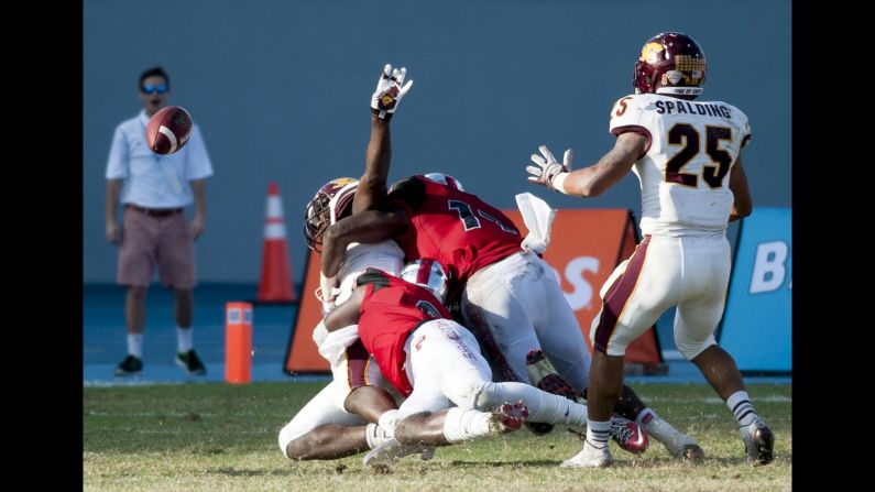 Central Michigan tight end Deon Butler, left, laterals the ball while being tackled by two Western Kentucky players Wednesday, December 24, at the Bahamas Bowl in Nassau, Bahamas. Central Michigan tossed several laterals on the play, scoring an incredible 80-yard touchdown as time expired. But the Chippewas missed the two-point conversion and fell just short of an implausible comeback. They lost 49-48 after rallying from a 49-14 fourth-quarter deficit.