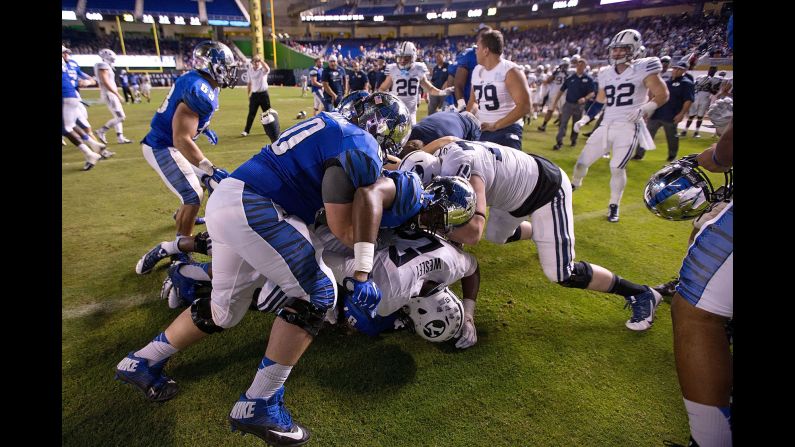Football players from BYU and Memphis tussle after a fight broke out at the end of the Miami Beach Bowl on Monday, December 22. Memphis won 55-48 in double overtime.