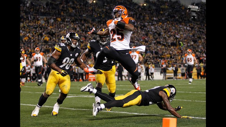 Cincinnati Bengals running back Giovani Bernard hurdles over Pittsburgh's William Gay to score a first-quarter touchdown Sunday, December 28, in Pittsburgh. The Steelers, however, would win the game 27-17 to clinch the AFC North title.