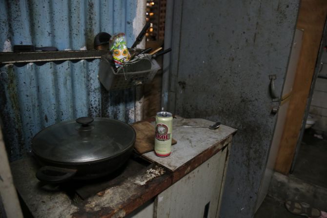 Rooftop dweller, Fung's simple kitchen setup outside his flat is next to his toilet.