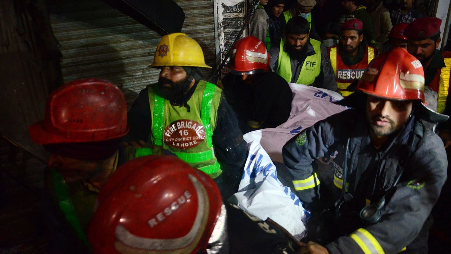 Volunteers move a victim after a fire in a four-storey building in Lahore, Pakistan on December 29, 2014.