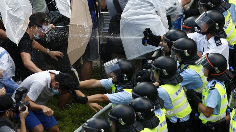 Riot police use pepper spray as they clash with pro-democracy protesters outside the government headquarters in Hong Kong on September 28, 2014. <a href="index.php?page=&url=http%3A%2F%2Fwww.cnn.com%2F2014%2F09%2F22%2Fasia%2Fgallery%2Fhong-kong-students-protest%2Findex.html">Demonstrations began</a> in response to China's decision to allow only Beijing-vetted candidates to stand in the city's 2017 election for chief executive. Protesters say Beijing has gone back on its pledge to allow universal suffrage in Hong Kong, which was promised "a high degree of autonomy" when it was handed back to China by Britain in 1997. The umbrella has become the defining image of the protest movement, used to shield protesters from tear gas and the elements.