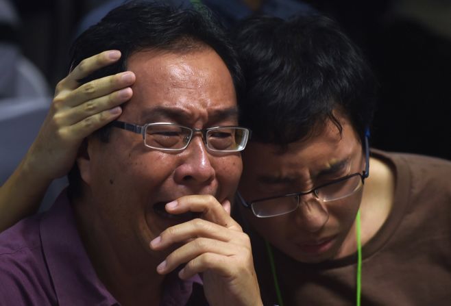 Relatives of missing passengers comfort each other December 30 at Juanda International Airport in Surabaya.