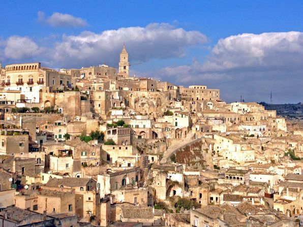 Matera overlooks the deep gorge of Murgia Park, cut by a dark river and overlooked by holes carved into the mountain on the other side.