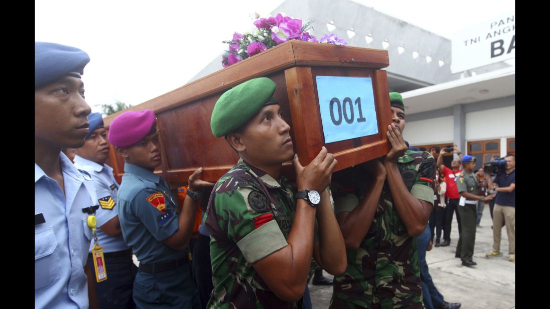 Indonesian soldiers carry a victim's coffin upon arrival at an air force base in Surabaya on Wednesday, December 31.