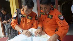 Indonesian Search and Rescue Helicopter pilots look over a map of the search area for debris from AirAsia Flight QZ8501 in the waters near Bangka Island, Indonesia on December 30, 2014.