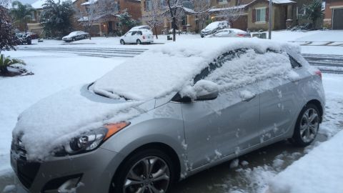 Snow covers a car -- you don't see this often in Southern California.