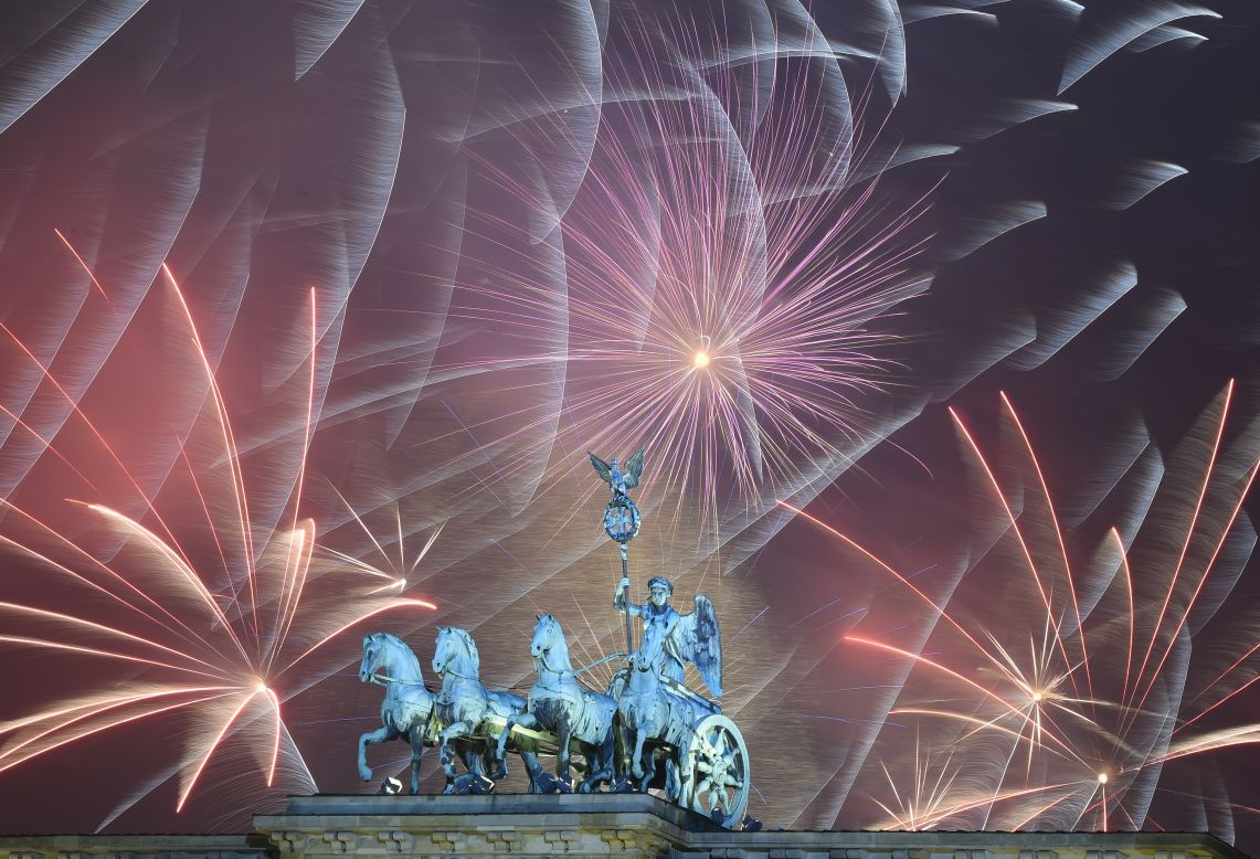 Fireworks explode behind the Brandenburg Gate in Berlin.