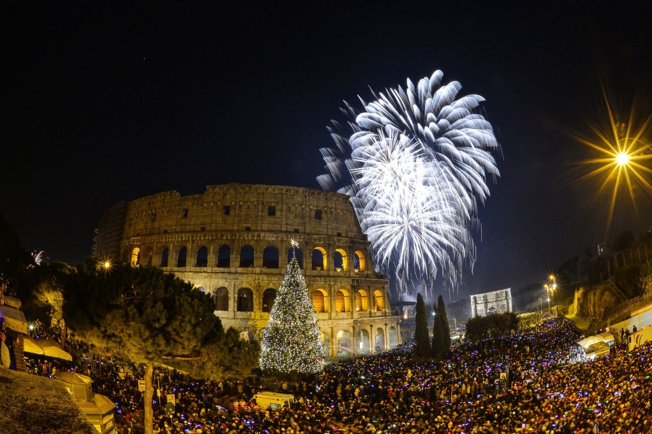 People cheer in front of Rome's ancient Colosseum.
