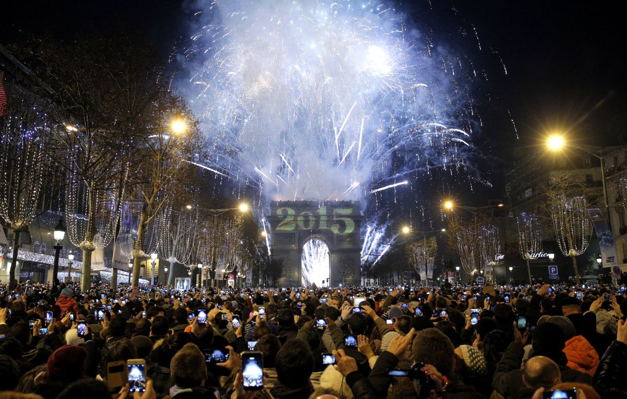 Revelers photograph fireworks over the Arc de Triomphe in Paris.