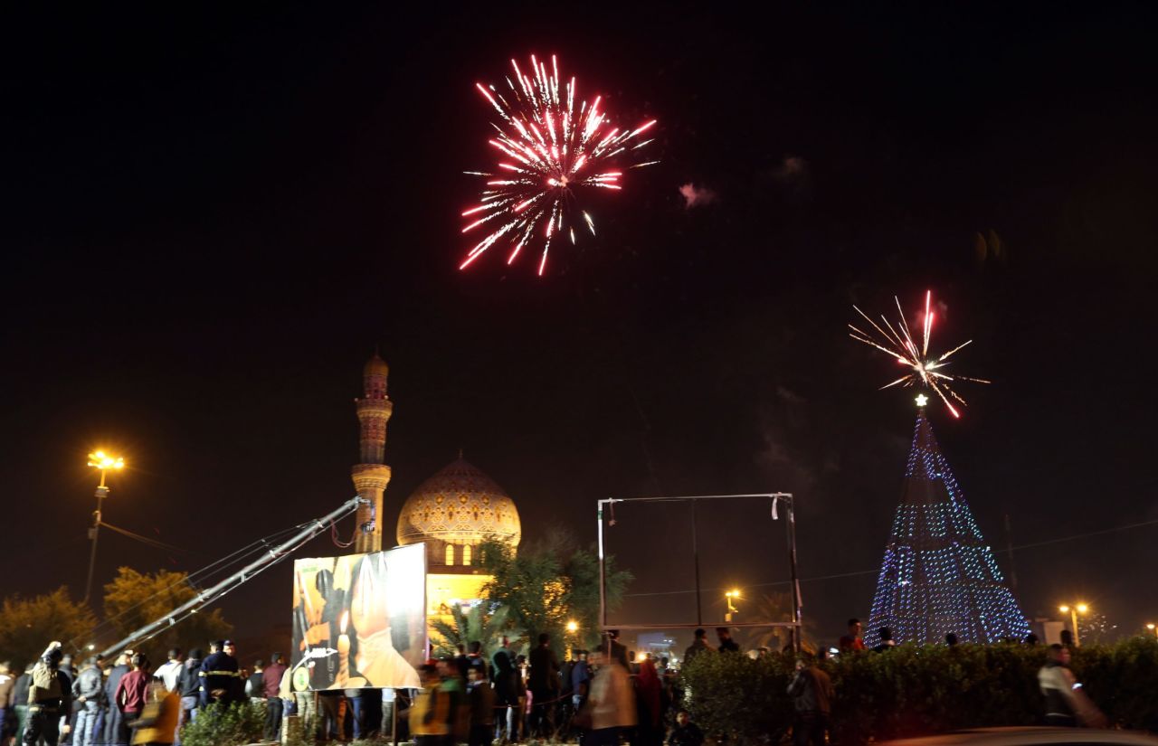 Iraqi crowds cheer as fireworks begin at Firdos Square in Baghdad.