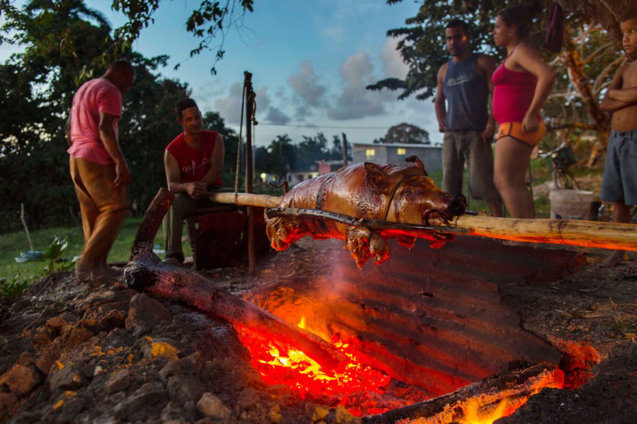 The Rodriguez Osorio family slow-roasts a pig over a charcoal fire for their New Year's Eve dinner in Campo Florido, Cuba.