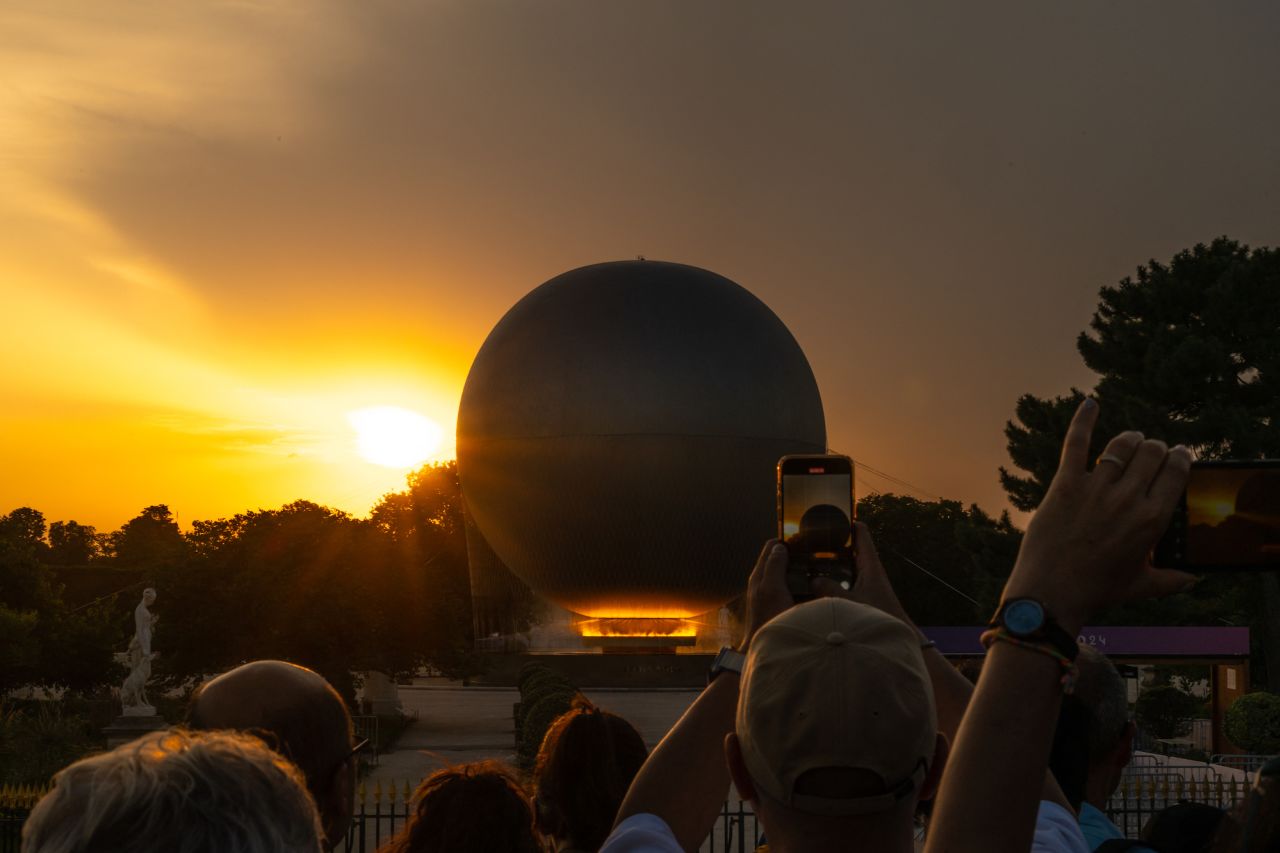 Visitors take photographs of the Olympic cauldron on Tuesday.