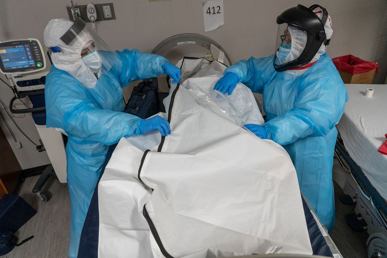 Medical staff members zip up a body bag which contains a deceased patient in the Covid-19 intensive care unit (ICU) at the United Memorial Medical Center in Houston, on December 6.