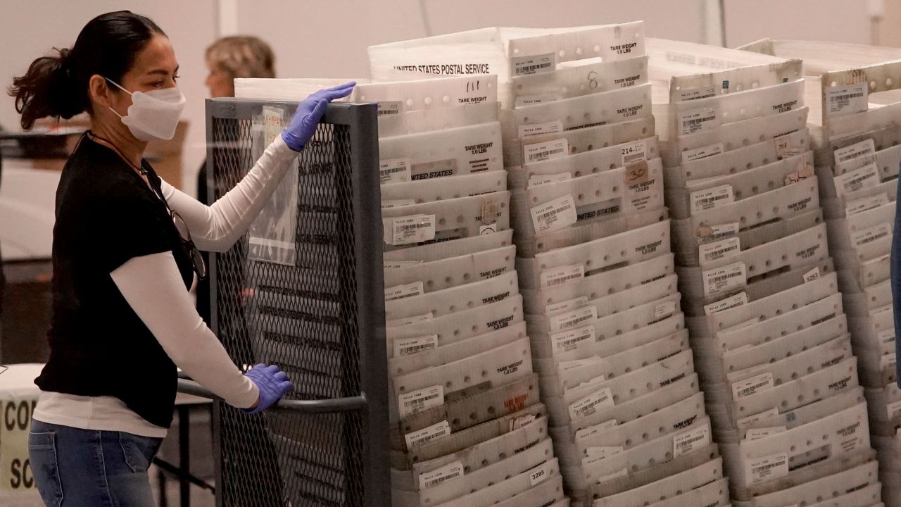 An election worker arrives with ballots Wednesday inside the Maricopa County Recorders Office in Phoenix.