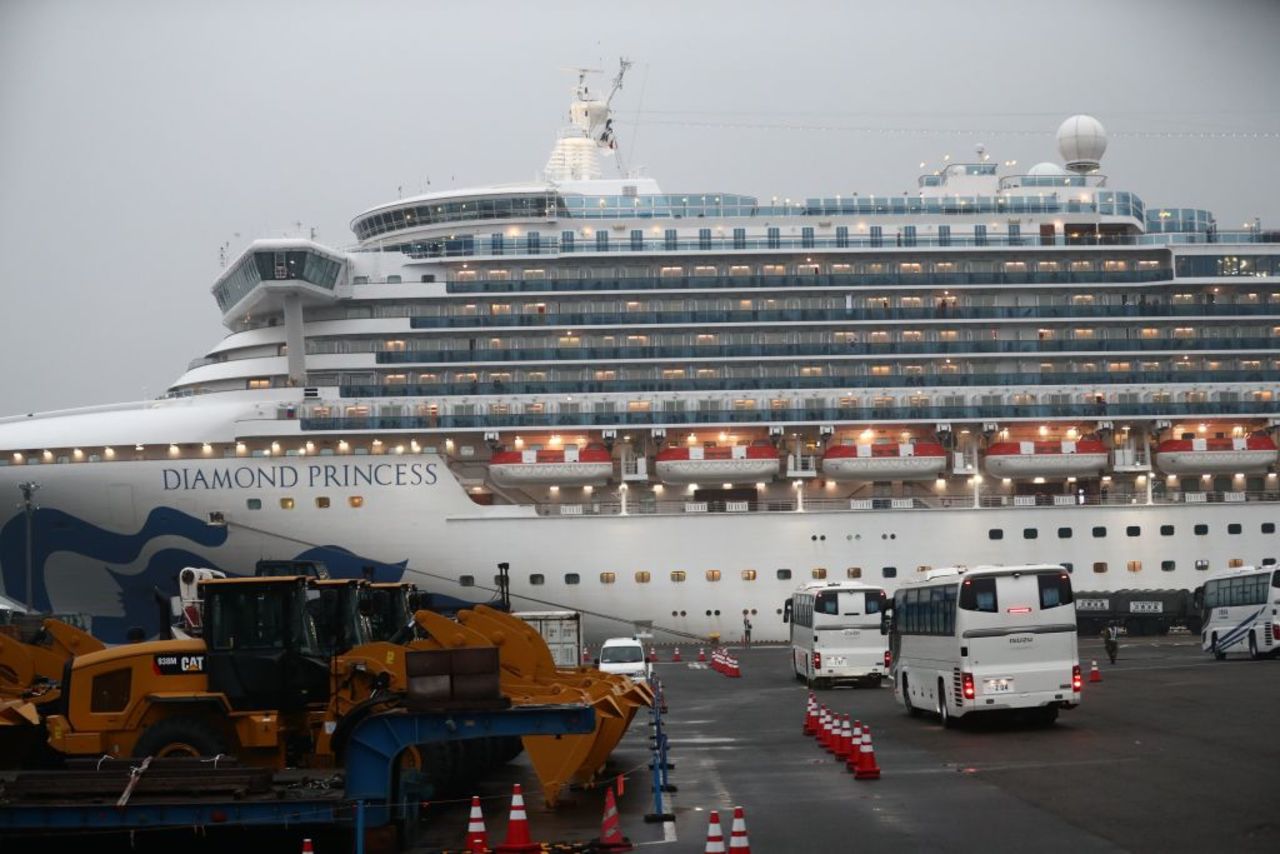 Two buses arrive next to the Diamond Princess cruise ship, with people quarantined onboard due to fears of the new coronavirus, at the Daikaku Pier Cruise Terminal in Yokohama port on February 16, 2020