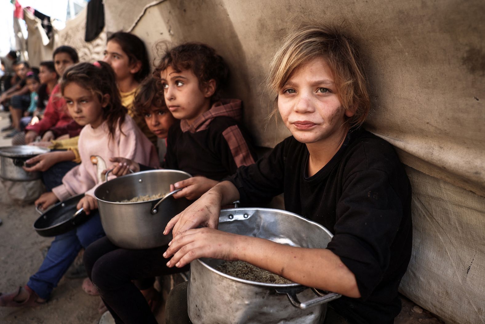 Palestinian children receive food at the Bureij refugee camp in central Gaza on Wednesday, November 6.