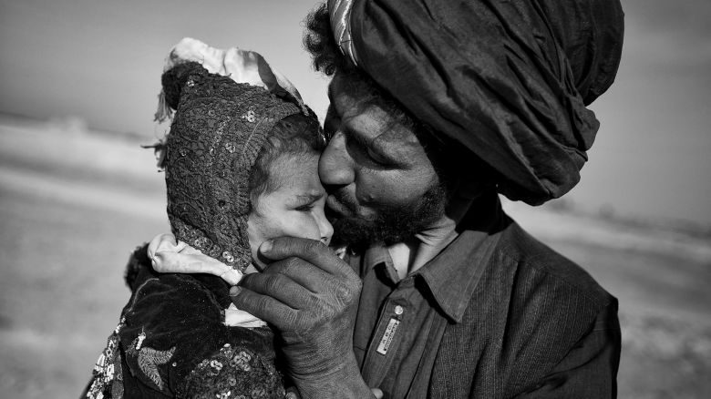 An Afghan nomad kisses his young daughter while watching his herd in Marjah, Helmand province, October 20, 2012.