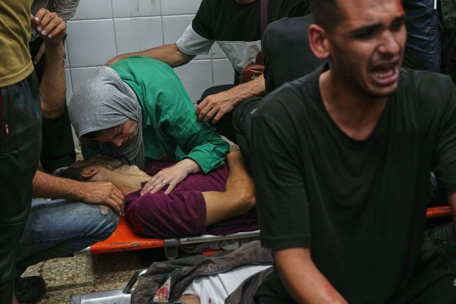 A Palestinian woman hugs the body of her husband, Yahya Barzaq, a photographer who was killed in an Israeli airstrike on a carpentry shop and a café in Deir al-Balah, Gaza, on Tuesday, September 30.
