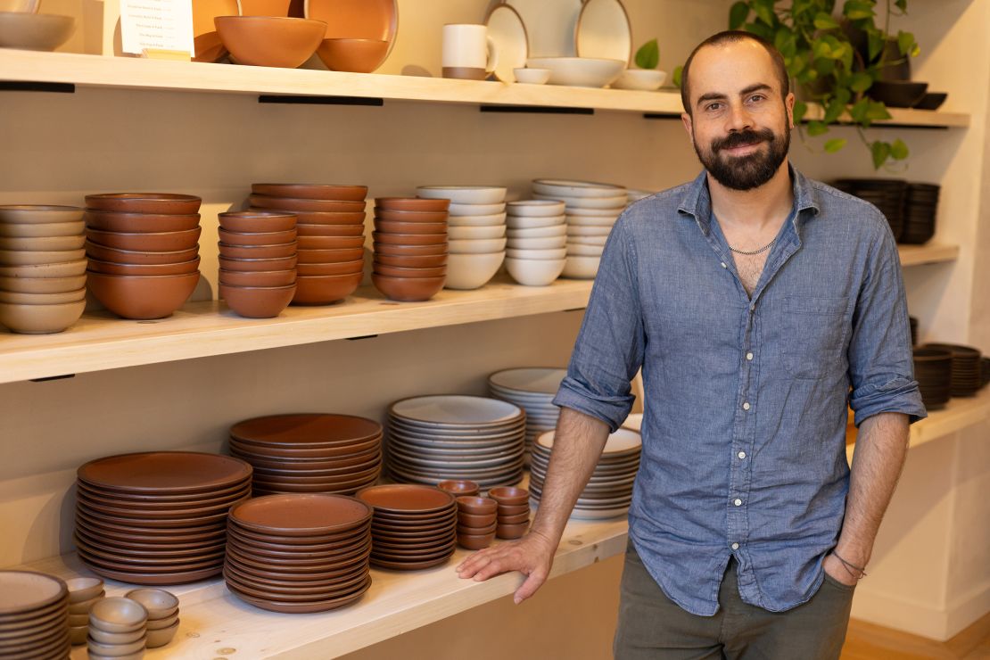 East Fork Pottery founder and CEO Alex Matisse stands next to his serveware.