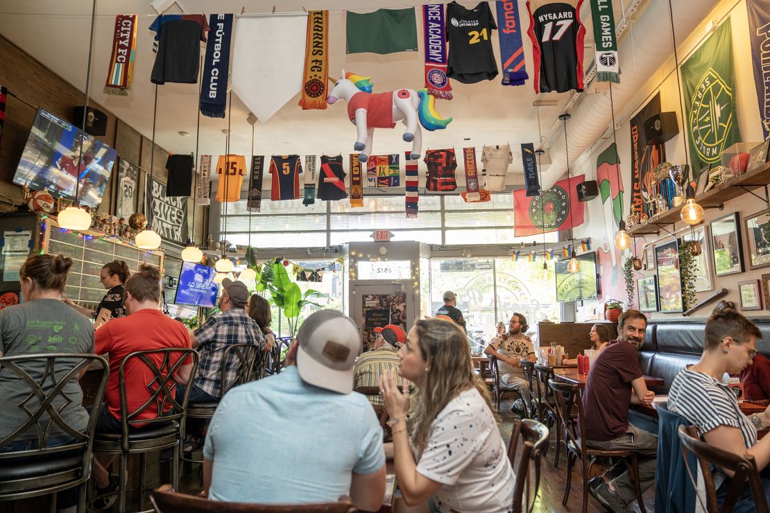 Sports fans taking in food, drinks and women’s sports at The Sports Bra in Portland, Oregon.