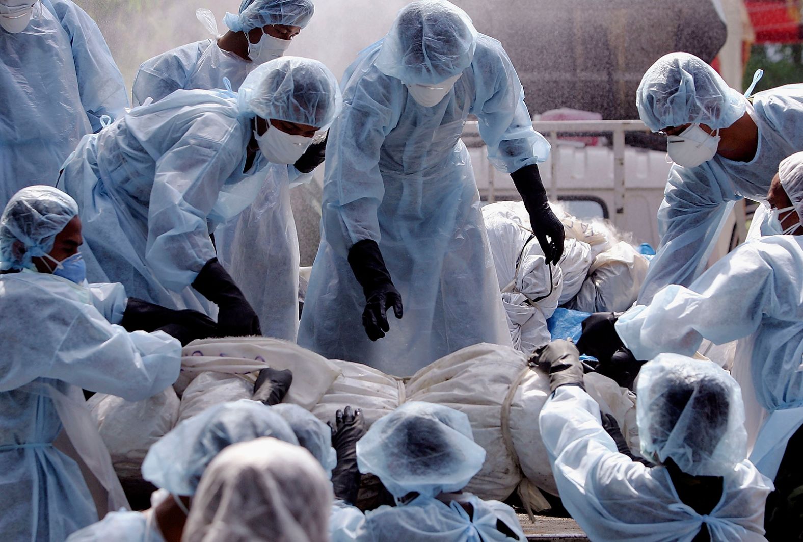 Medical workers load a body onto a truck at a makeshift morgue inside a Buddhist temple in Takuap Pa, Thailand.