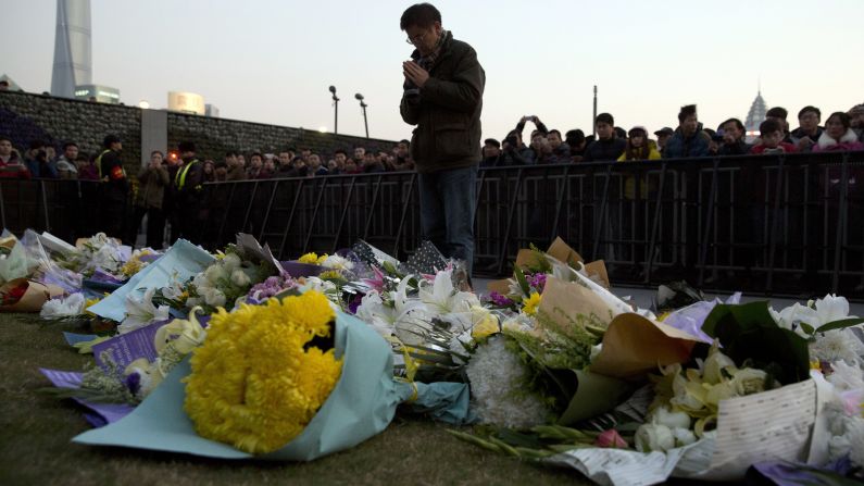 A man prays after laying flowers at the site of a deadly stampede in Shanghai, China, on Thursday, January 1. The city government said 36 people died and 47 were injured in the incident, which occurred during New Year's Eve festivities, less than a half-hour before midnight. Many of the victims were female students, state media reported.