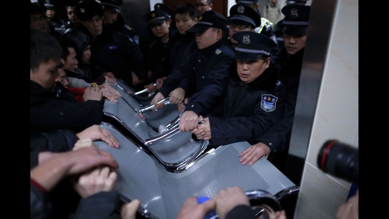 Security guards use a bench to hold off relatives of victims trying to enter the emergency area of a hospital in Shanghai. One woman told state broadcaster CCTV that relatives had been waiting for hours for information about their loved ones.<br />