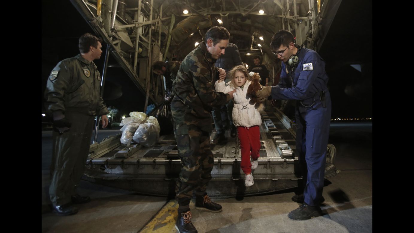 Serafina Gondolo, a rescued passenger of <a href="http://www.cnn.com/2014/12/28/world/gallery/greece-italy-ferry-fire/index.html">the Norman Atlantic ferry accident,</a> is helped off an airplane as she arrives at an air base in Greece on Monday, December 29. At least 10 people died after <a href="http://www.cnn.com/2014/12/28/world/europe/ferry-fire-italy-greece/index.html" target="_blank">the ferry caught fire in the Adriatic Sea,</a> but more than 400 were saved, according to the Italian coast guard.