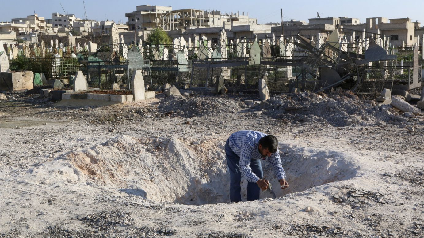 A man in Khan Sheikhoun, Syria, inspects a hole in the ground after what activists said was an airstrike carried out by forces loyal to Syrian President Bashar al-Assad on Friday, December 26.