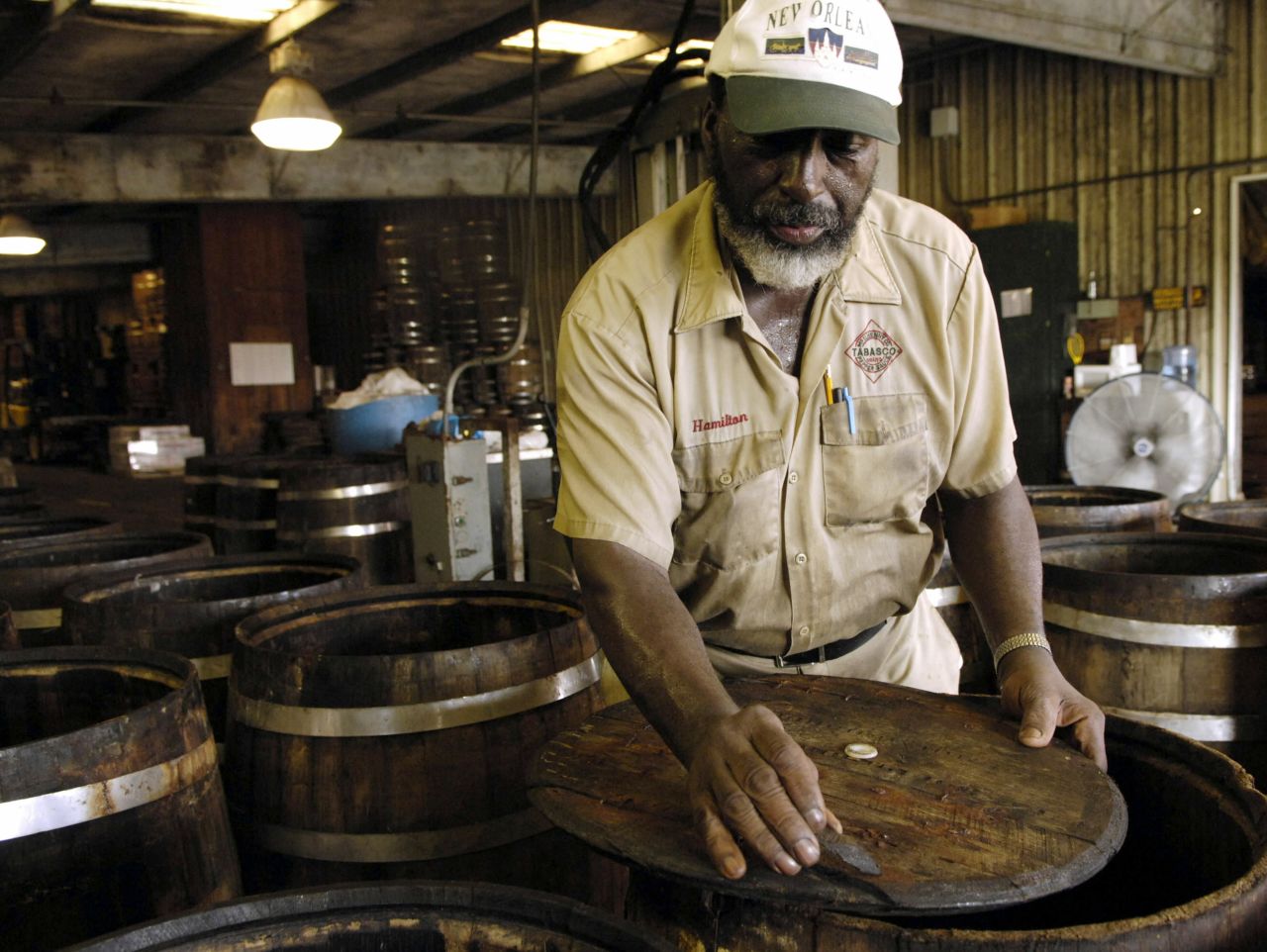 Master barrel cooper Hamilton Polk, now retired, is shown preparing oak barrels for pepper mash.