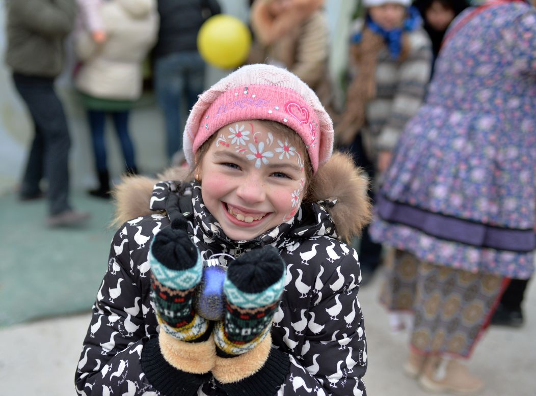 DECEMBER 29 -- UKRAINE, KIEV:  A young girl smiles while holding an ornament during a New Years celebration at an assistance center. Thousands of families displaced by fighting in eastern Ukraine are receiving humanitarian assistance at a center set up by volunteers in Kiev.