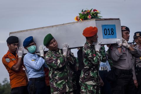 Members of an Indonesian search team carry a coffin at Iskandar Air Base on Friday, January 2.