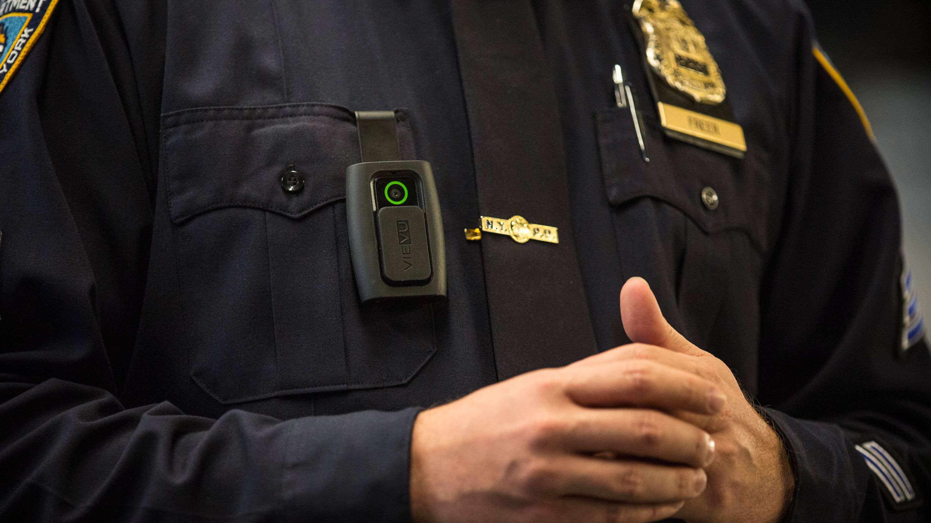 NYPD Sgt. Joseph Freer demonstrates how to use a body camera during a press conference.