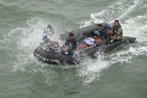 Members of the Indonesian navy return to the vessel with remains recovered from the crash area.