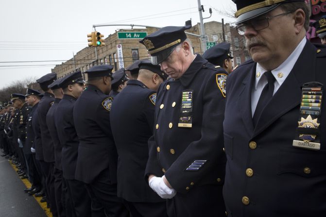 Some police officers turn their backs as de Blasio speaks during the funeral.