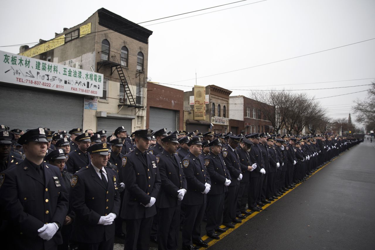 Police officers stand at attention during the funeral.
