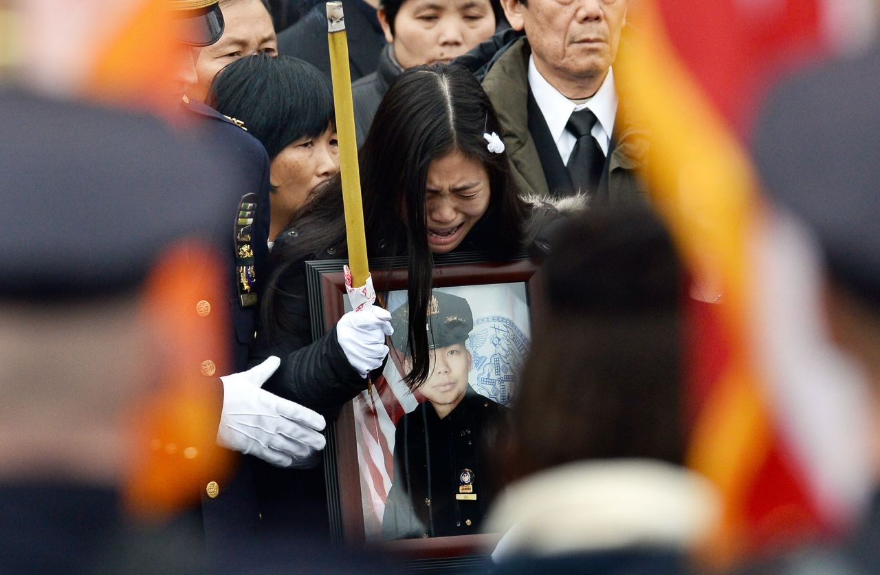 Pei Xia Chen, Liu's widow, cries while holding a picture of her husband.
