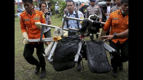 Search and rescue personnel carry seats from the flight on Monday, January 5.