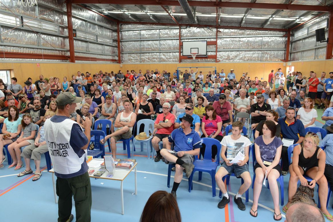 Residents from the town of One Tree Hill gather at a local elementary school to hear the latest information on bushfires. More than 20 homes have been damaged in the blaze so far and more than 1,000 properties have been left without power.