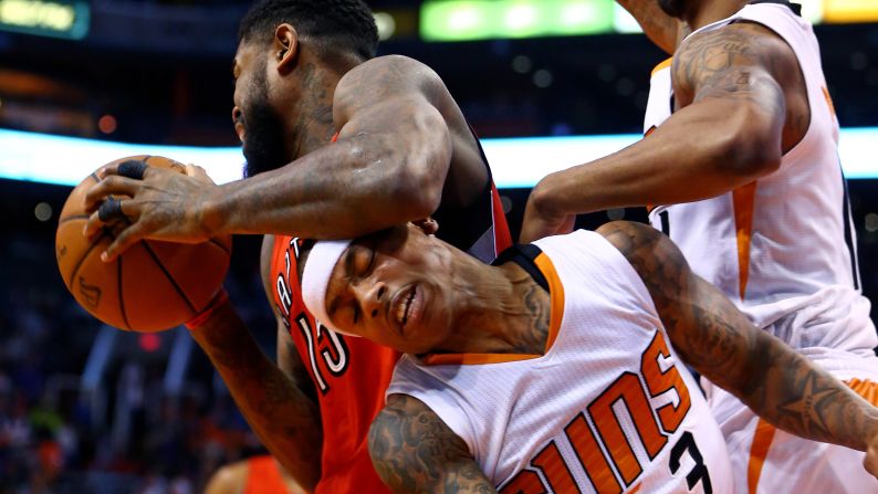 Phoenix Suns guard Isaiah Thomas, center, is fouled by Toronto's Amir Johnson during an NBA game in Phoenix on Sunday, January 4.