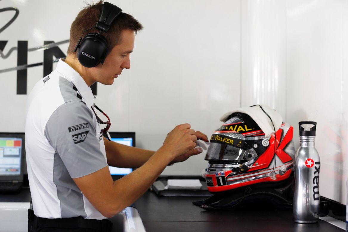 Fitness trainers are are multitaskers. Here, Antti Vierula, the former personal trainer for McLaren's Kevin Magnussen, tinkers with the Dane's helmet prior to a race weekend.
