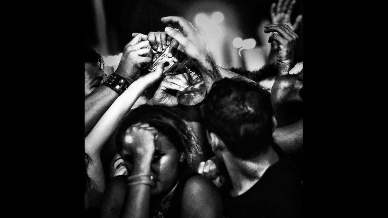 People reach for a bottle at an Avenged Sevenfold performance in 2013.