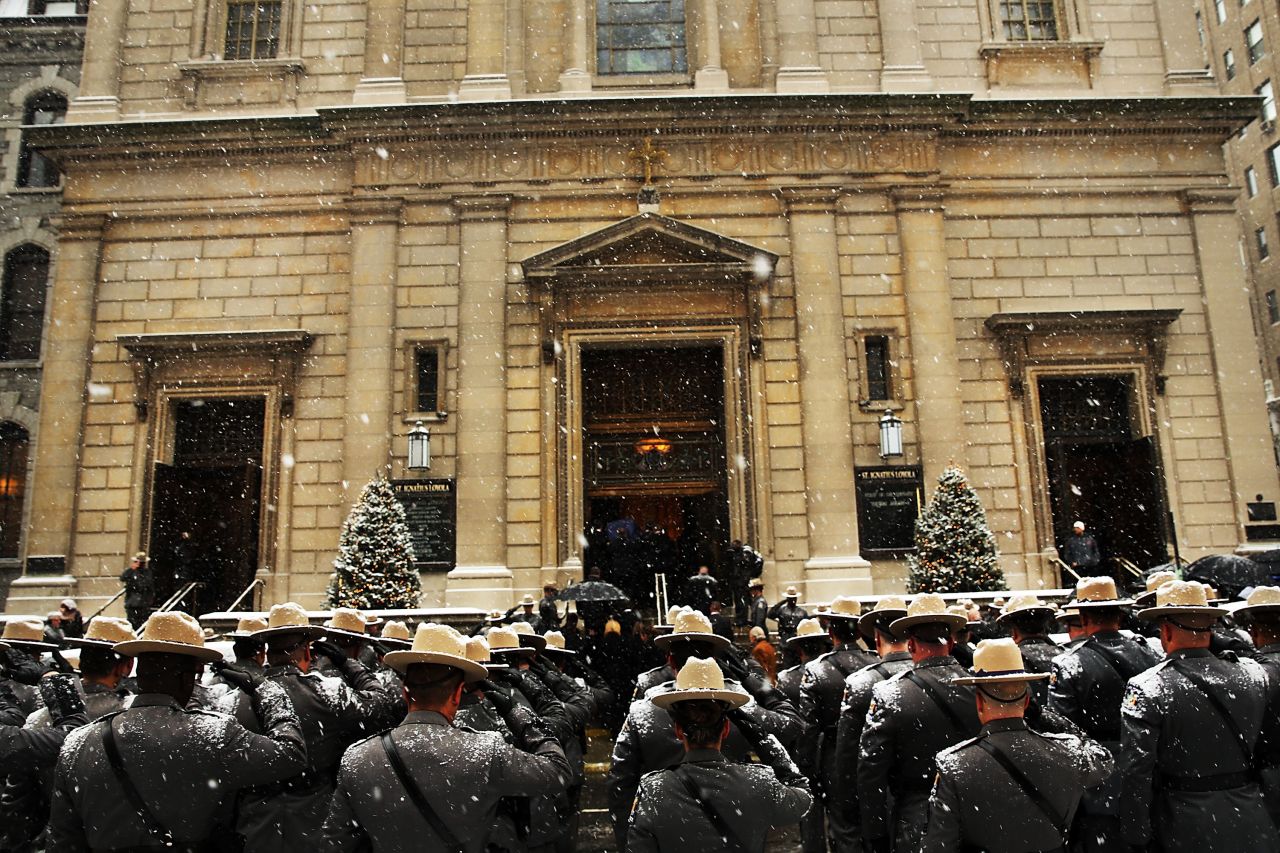 New York State Police wait for the hearse carrying Cuomo's casket.