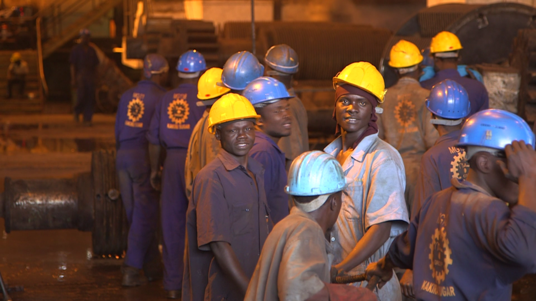 Workers smile for the cameras at the Kakira plant. After Amin was deposed in 1979, the Madhvani family returned to Uganda and looked to piece together their shattered business.